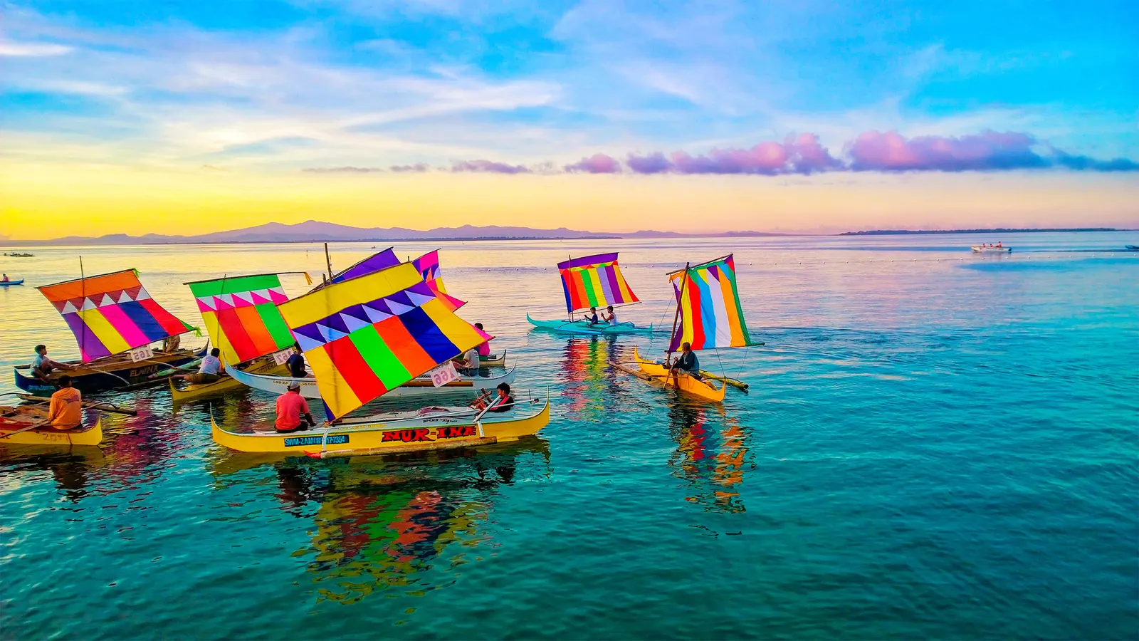 Rows of vinta boats with colorful sails on the water in Zamboanga.