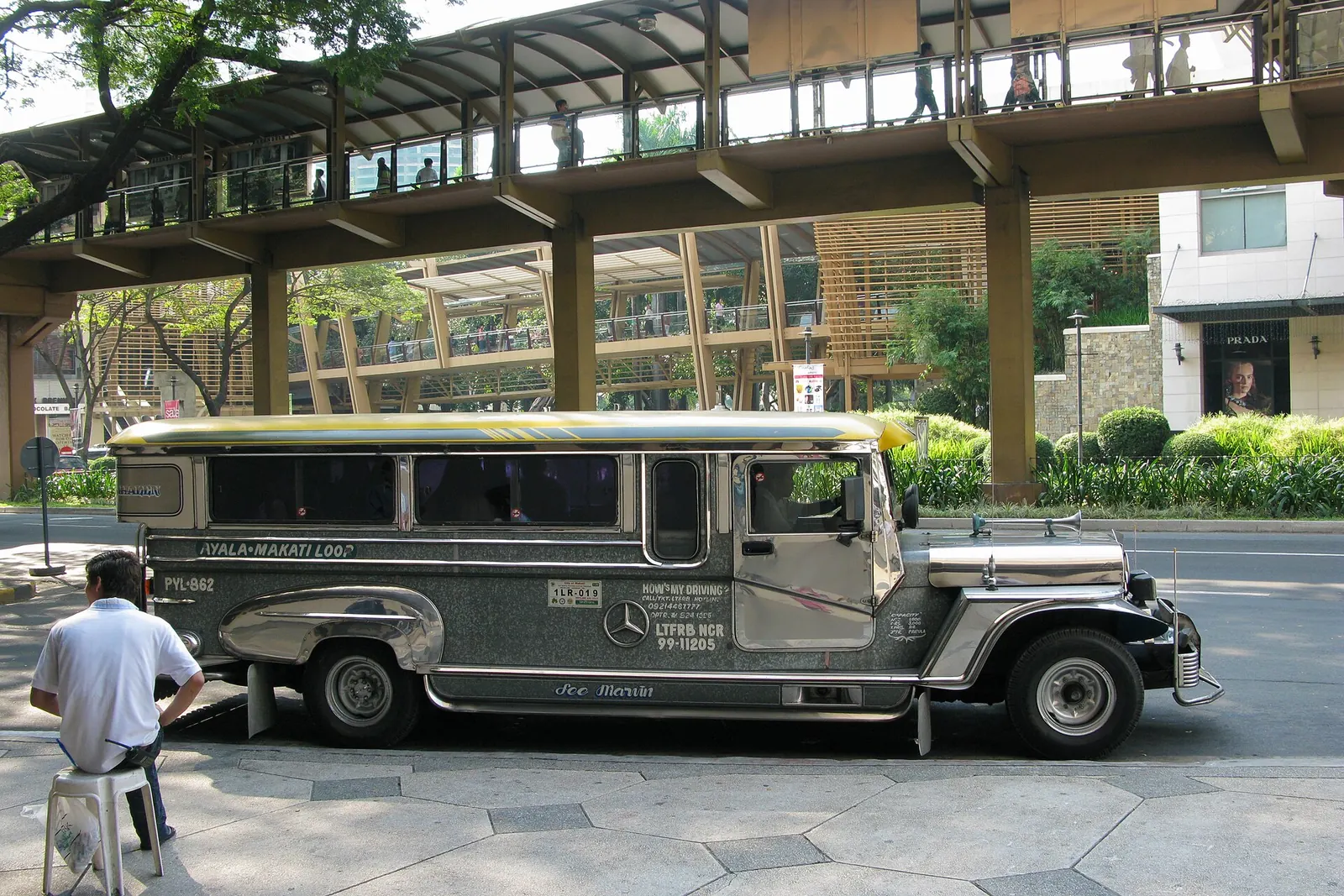 A silver jeepney beside a Manila street.