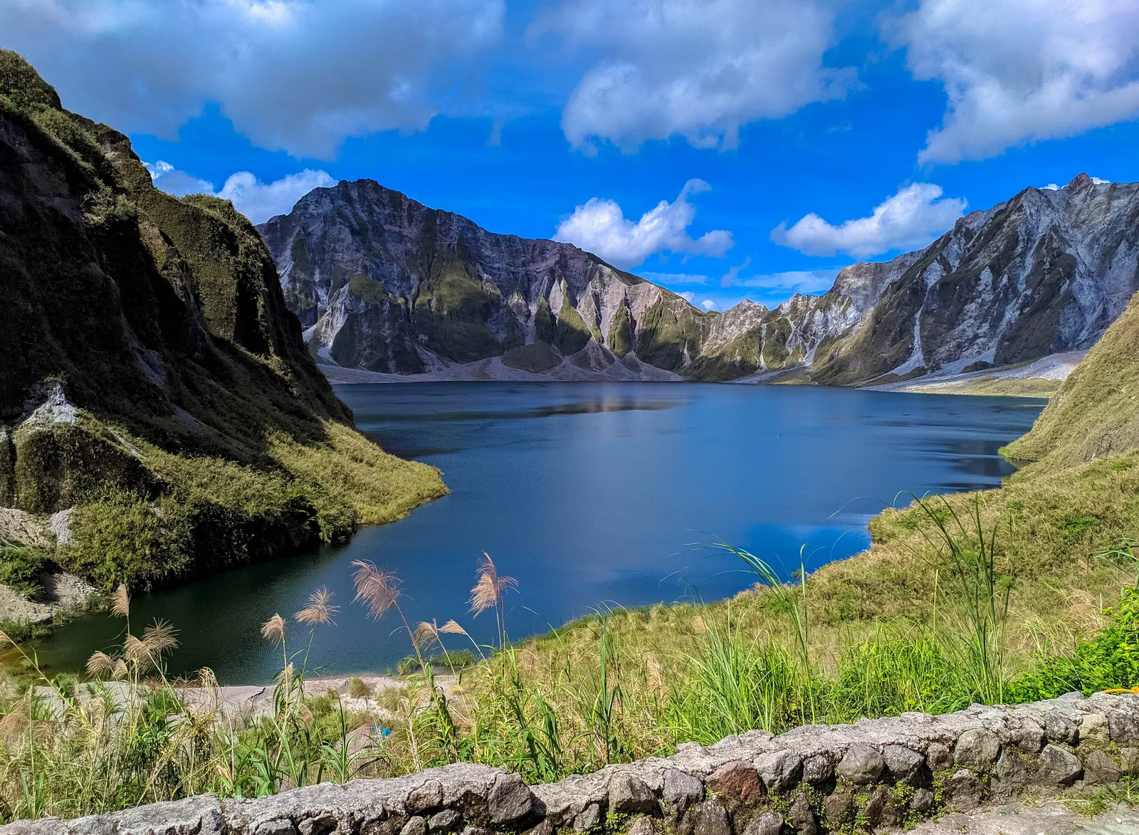 Blue-green water below the steep crater walls of Mount Pinatubo.